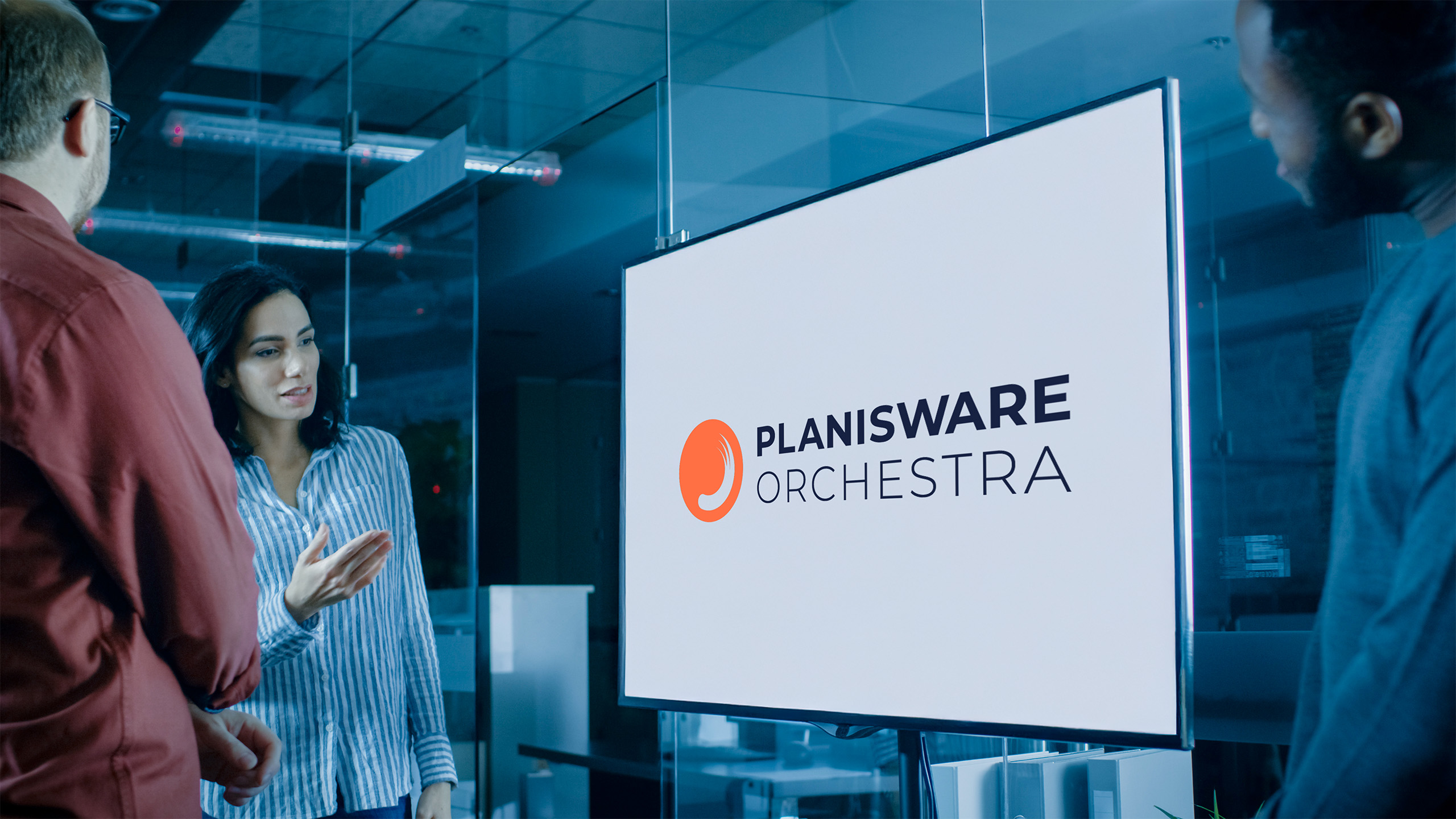 Foto eines Team Meetings im Konferenzraum, auf Bildschirm wird Logo von Planisware Orchestra angezeigt